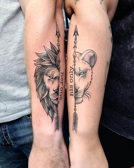 two people with tattoos on their arms holding each other's hands and one has an arrow