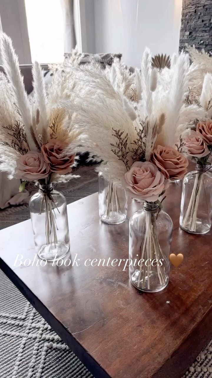 vases with flowers and feathers on a coffee table