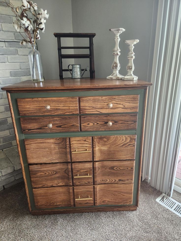 a wooden dresser with drawers and vases on top