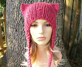 a female mannequin wearing a pink knitted hat with cat ears on it