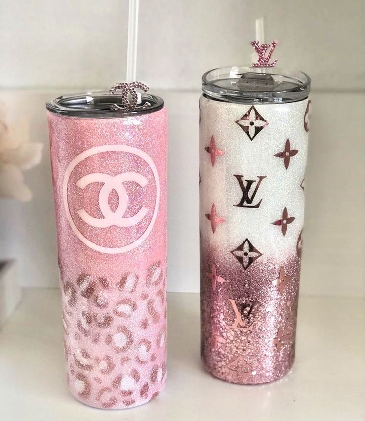 two pink and white tumblers sitting next to each other on top of a counter