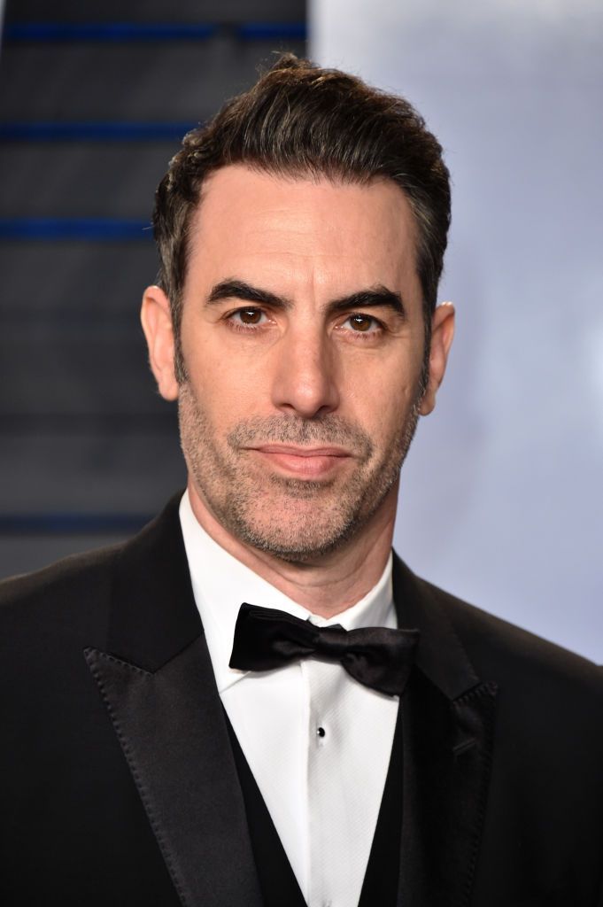 a close up of a person wearing a tuxedo and a suit with a bow tie