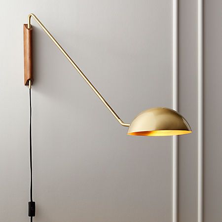 a wall light with a long arm and a wooden stick hanging from it's side