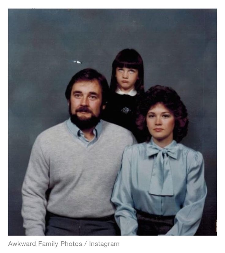 an older man and two younger women pose for a photo in front of a gray background