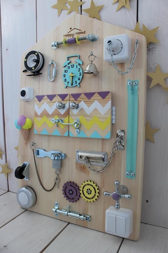 a wooden board with magnets, keys and other items attached to it on the wall