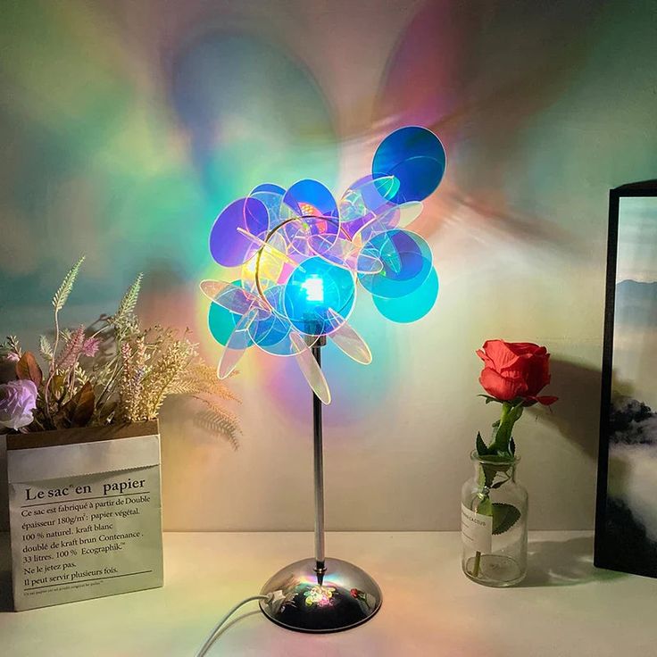 a lamp that is sitting on a table next to a vase with flowers in it