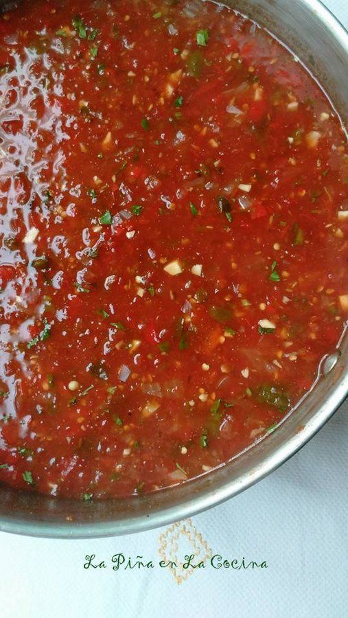 a pan filled with red sauce on top of a table