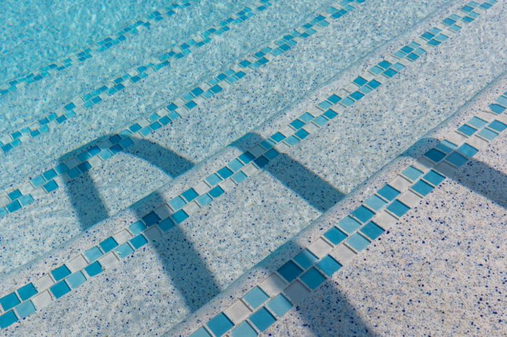 an empty swimming pool with blue tiles and water