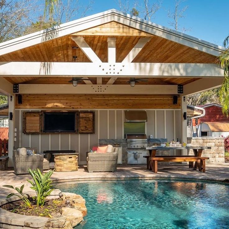 an outdoor living area with a pool and grill