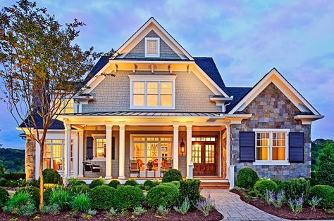 a large house that is lit up with lights on it's front porch and windows