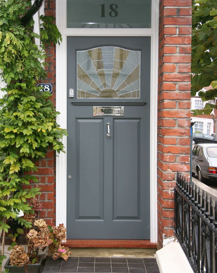 a grey front door on a brick house