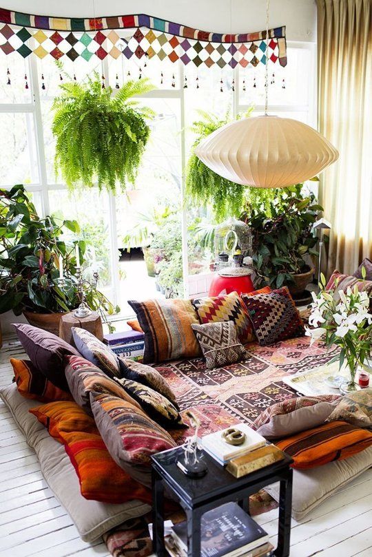 a living room filled with lots of furniture and plants on top of the windowsill