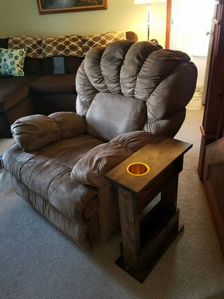 a brown recliner chair sitting in a living room next to a wooden end table