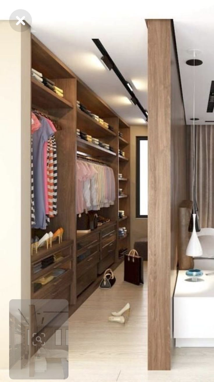 a walk in closet with clothes and shoes on the shelves