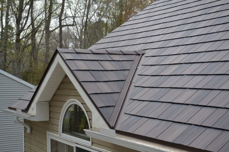 the roof of a house with two dormers and one has a window on it