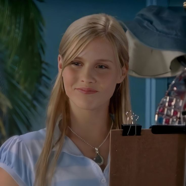 a woman with long blonde hair standing next to a box