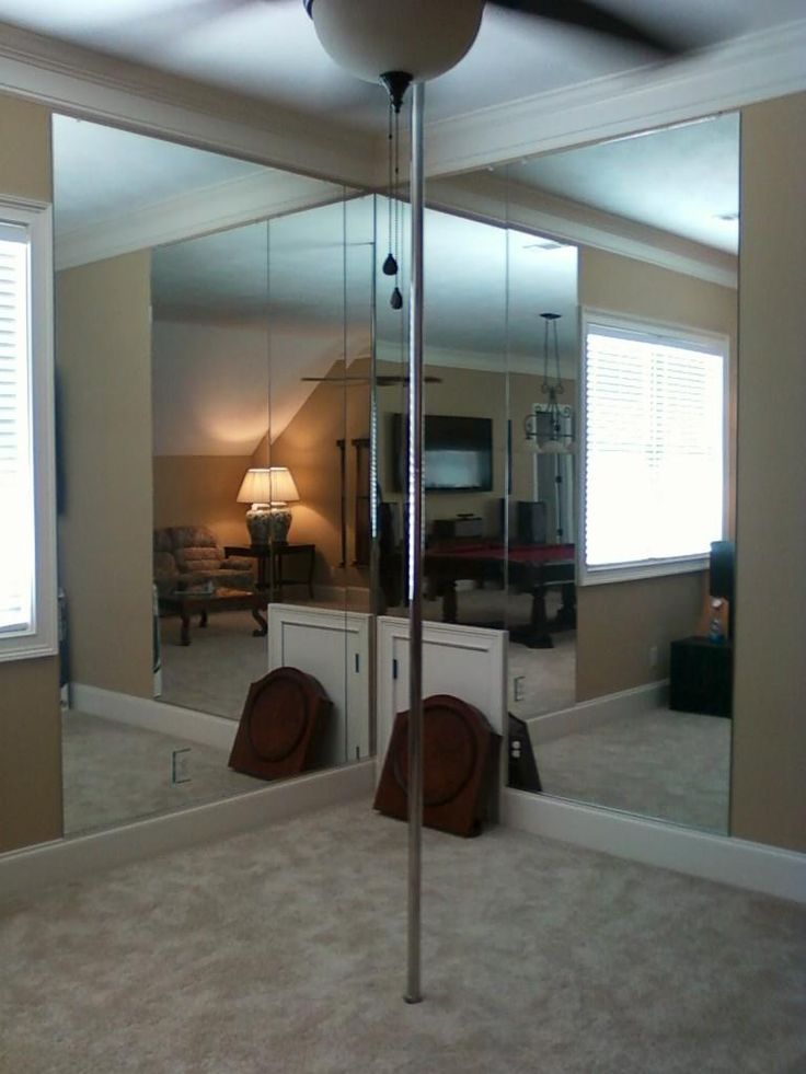 a large mirror in the middle of a room with two mirrors on it's sides