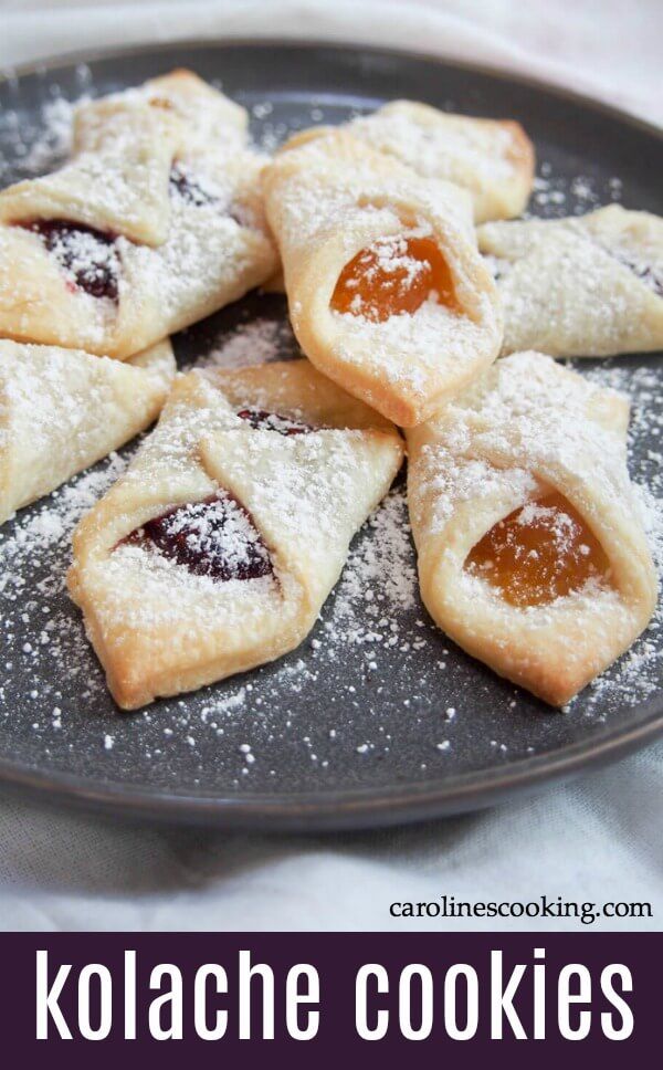 some cookies are sitting on a plate with powdered sugar and jelly in the middle