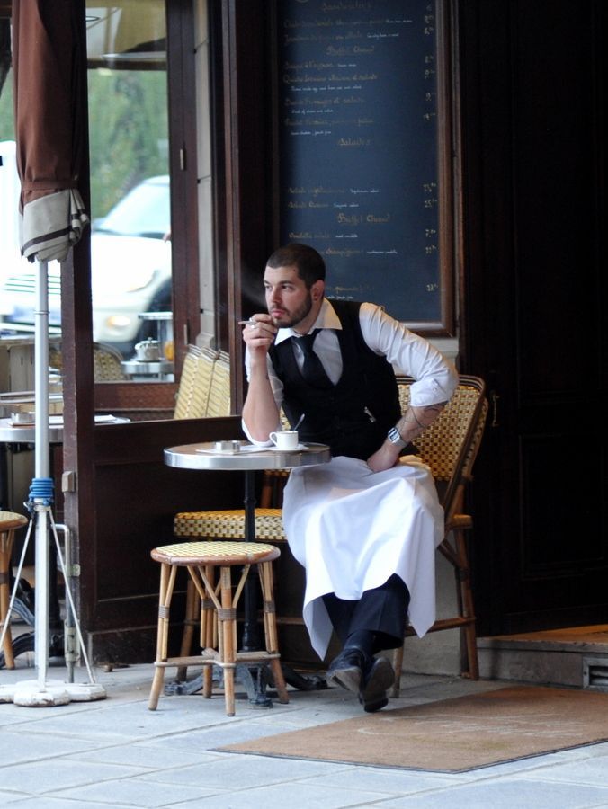 a man sitting at a table in front of a restaurant