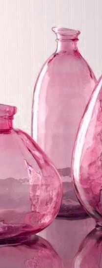 three pink glass vases sitting on top of a table