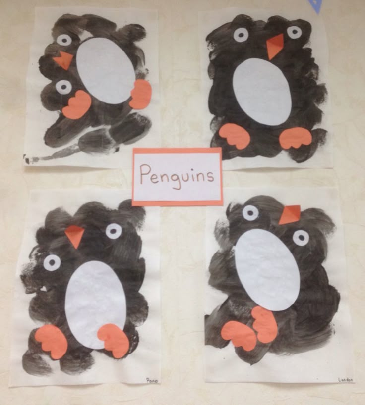 four penguins made out of construction paper with the word penguins on them, and one penguin holding an orange piece of paper