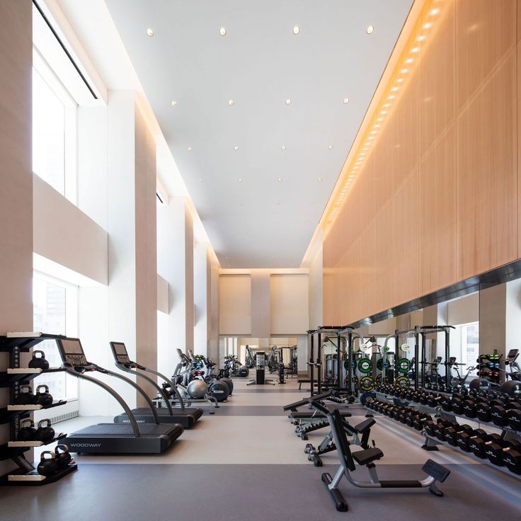 a large gym with rows of treadmills and exercise machines