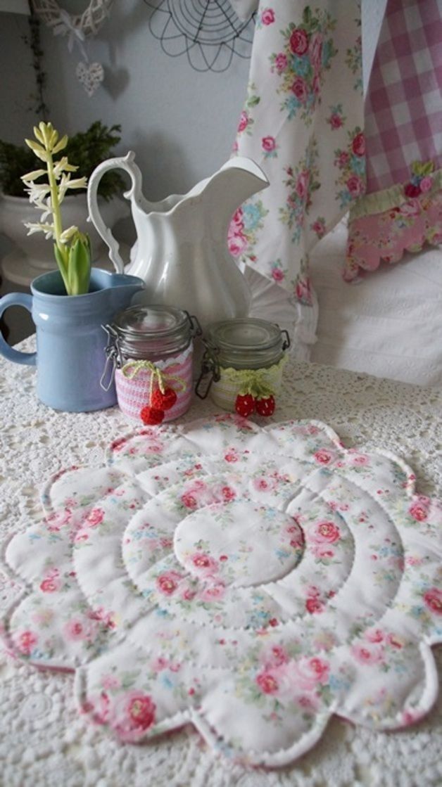 a table topped with lots of white doily covered in pink and blue flowery designs