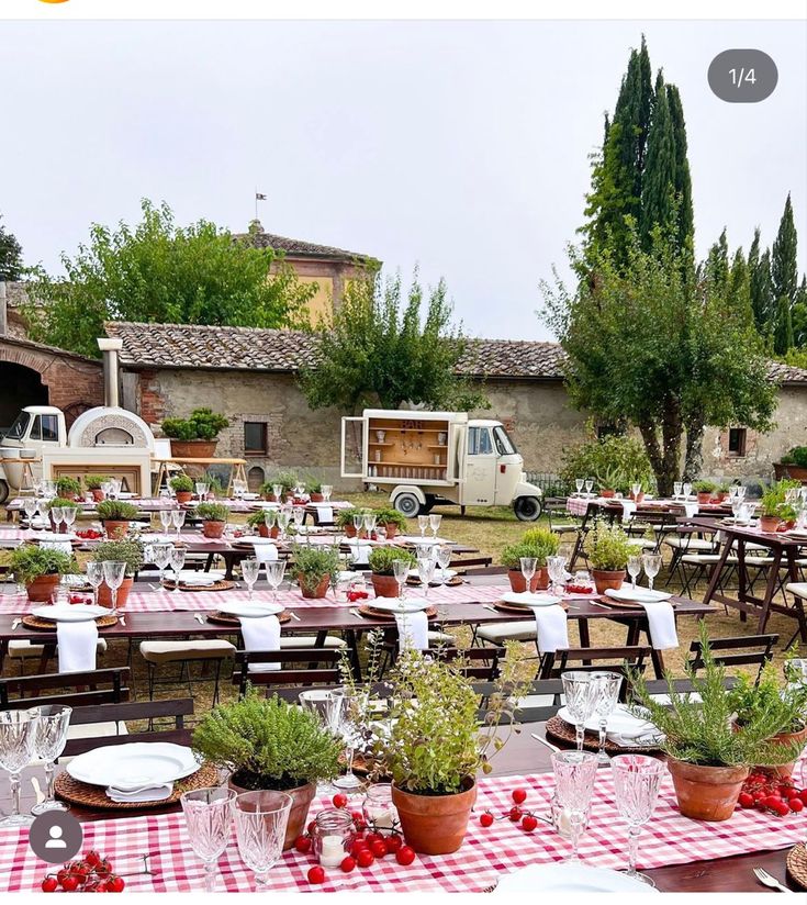 an outdoor dining area with tables, chairs and flowers in pots on the table top