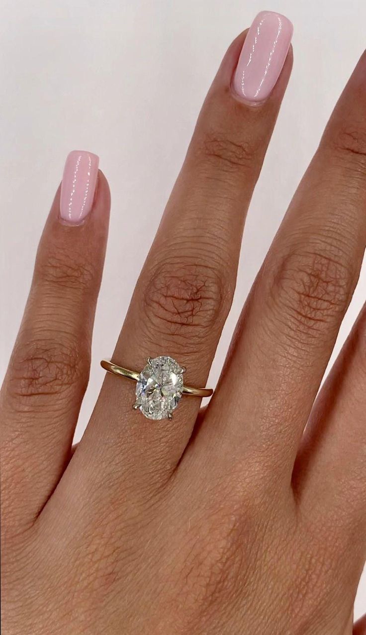 a woman's hand with a ring on it and a diamond in the middle