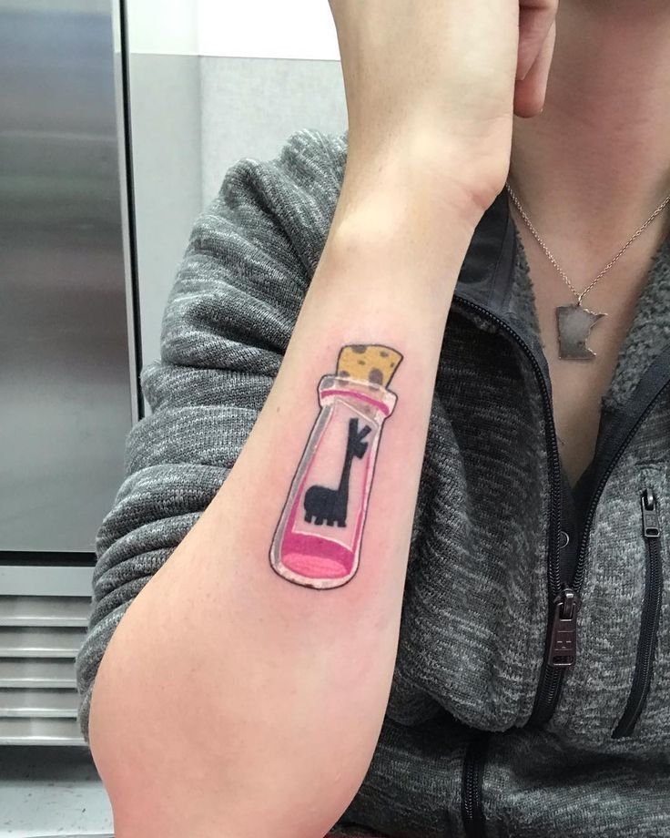 a woman with a cat in a bottle tattoo on her left arm and right arm