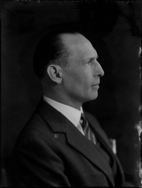 an old photo of a man in a suit and tie looking off to the side