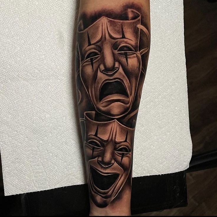 a man's arm with two faces on it and one is wearing a mask