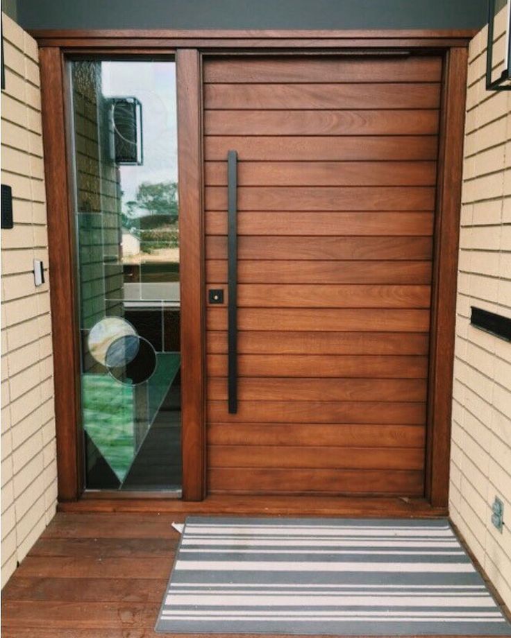 a modern wooden door with glass panels and sidelights on the outside of a house