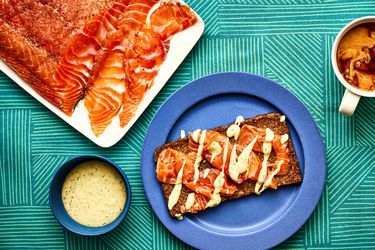 two plates with food on them next to some dipping sauces and other foods sitting on a table