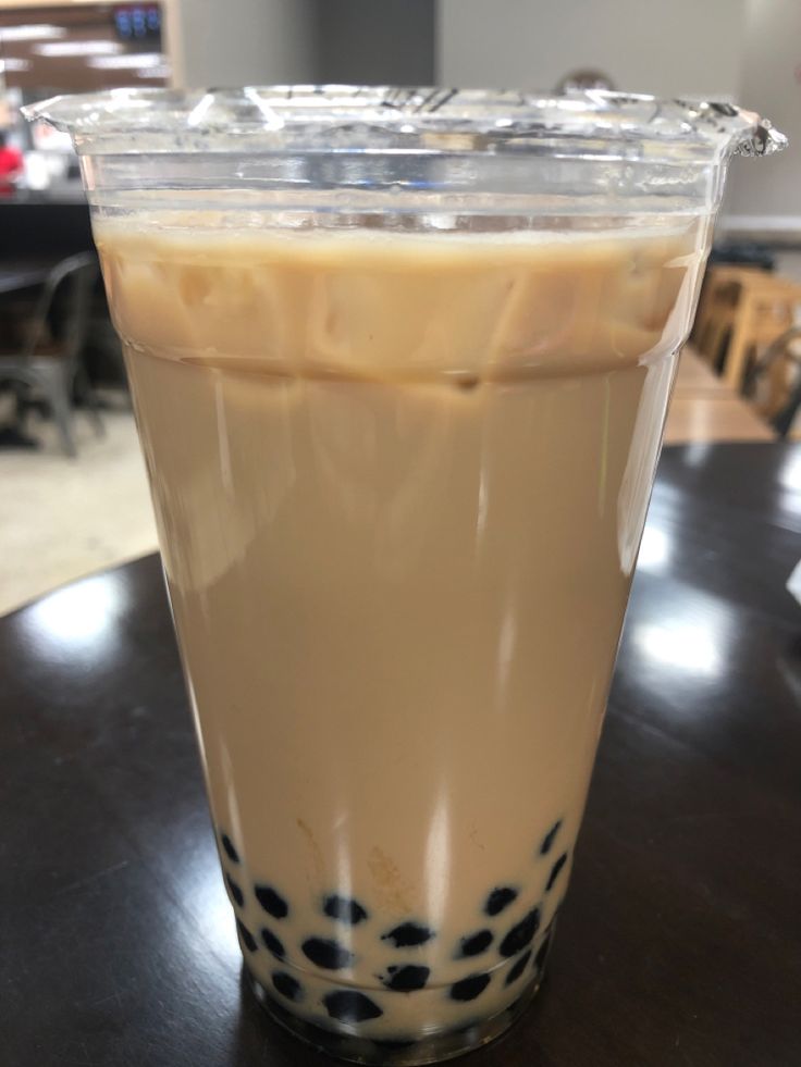 a drink in a plastic cup sitting on top of a table