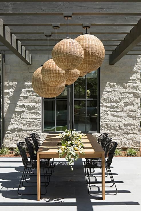 an outdoor dining table with four hanging honeycombs on it's ceiling above