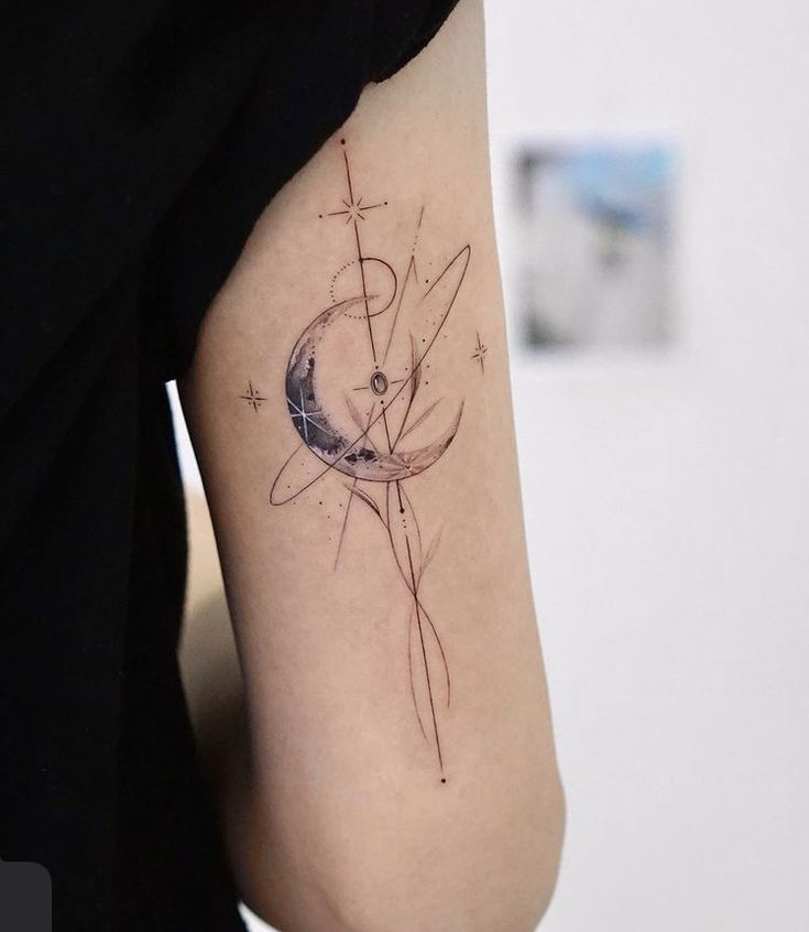 a woman's arm with a tattoo on it that has an image of the moon and stars