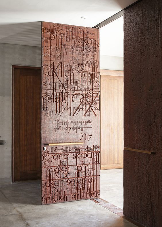 an open door with writing on it in the middle of a room next to two wooden doors