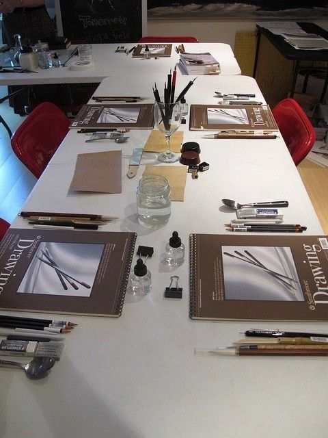 the table is set up with several books and pens