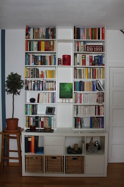 a bookshelf filled with lots of books in a living room