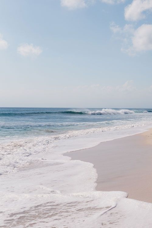 an ocean beach with waves coming in to shore