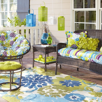 an outdoor living room with furniture and decor