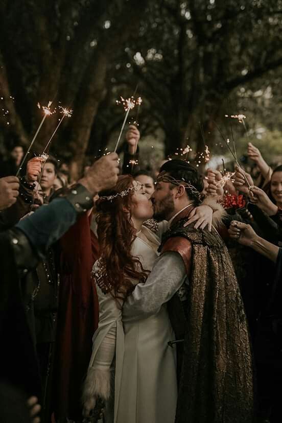 a group of people standing around each other holding sparklers