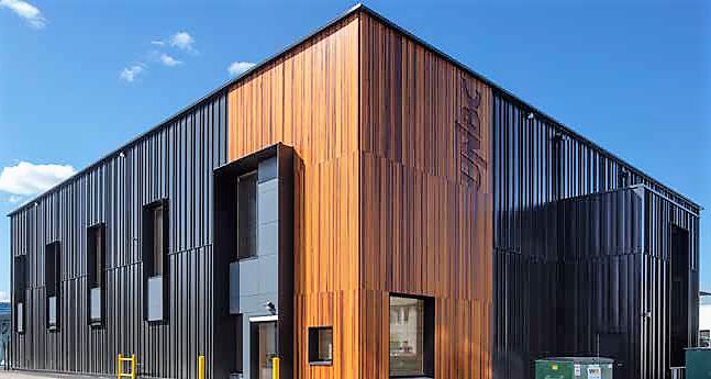 an industrial building with wooden panels on the side