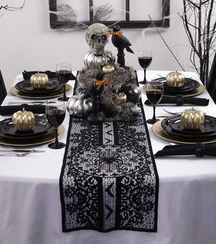 the table is set with black and gold decorations