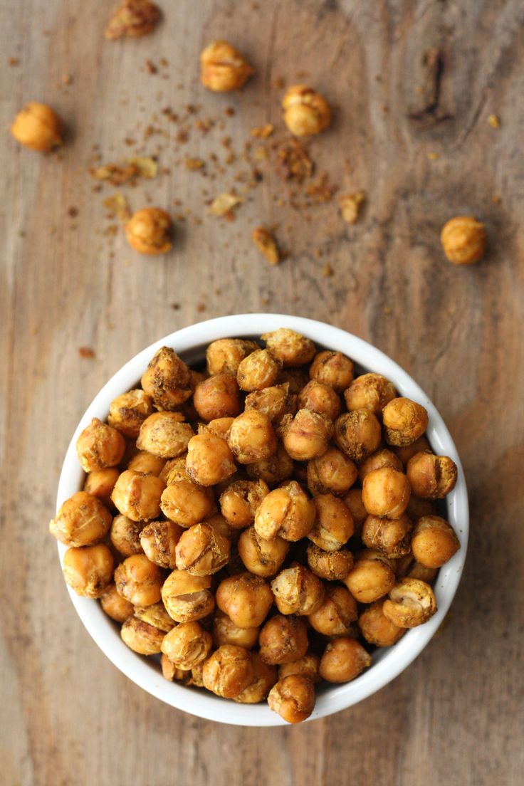 a white bowl filled with nuts on top of a wooden table