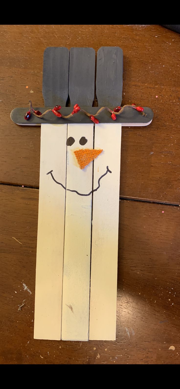 a snowman made out of skis on top of a wooden floor