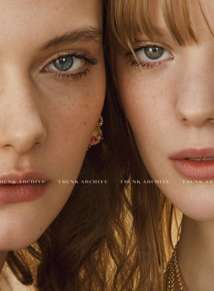 two young women with blue eyes and long hair are looking at the camera while wearing gold jewelry