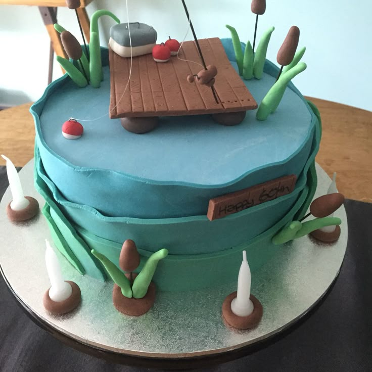 a cake decorated with an image of a sailboat on the water and reeds