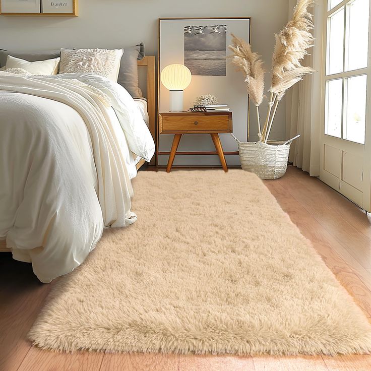 a bed room with a neatly made bed and a rug